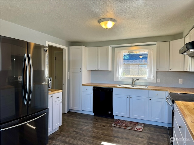 kitchen featuring black dishwasher, stainless steel fridge, white cabinetry, and wood counters