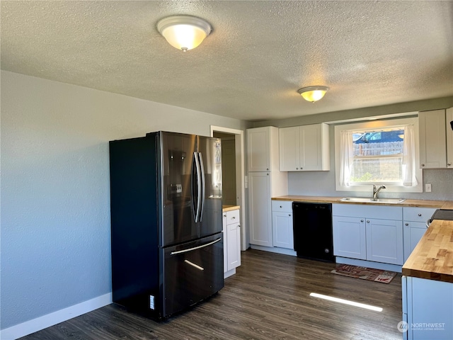 kitchen with white cabinets, sink, stainless steel refrigerator, black dishwasher, and wood counters