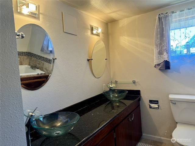 bathroom with a bath, vanity, and toilet