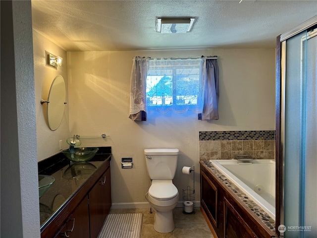 bathroom featuring tile patterned flooring, a textured ceiling, a bath, vanity, and toilet