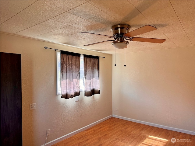 empty room with ceiling fan and hardwood / wood-style flooring