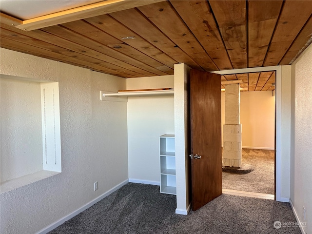 unfurnished bedroom with dark carpet and wood ceiling