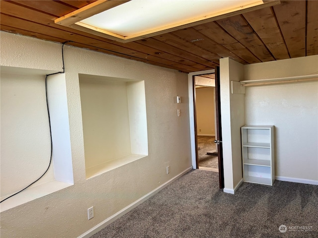 interior space with dark colored carpet and wooden ceiling