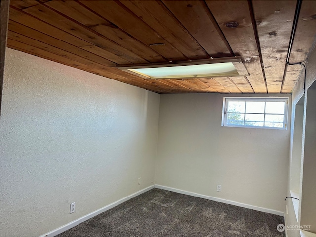 basement with dark carpet and wooden ceiling