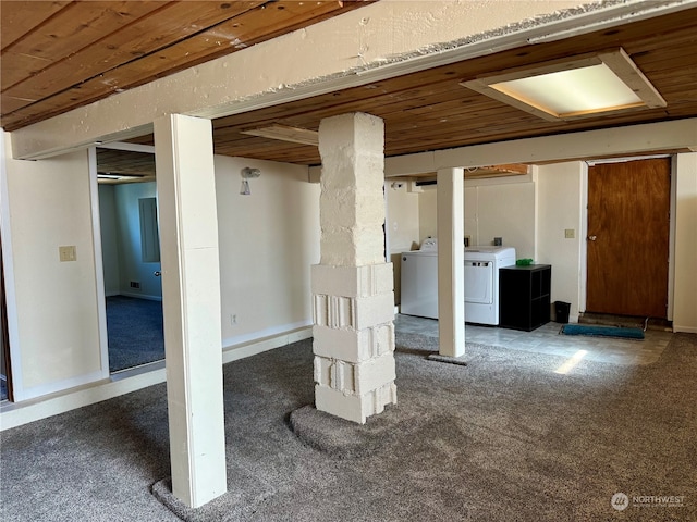 basement featuring washer and clothes dryer, wood ceiling, and dark carpet