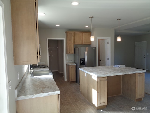 kitchen with wood-type flooring, stainless steel appliances, hanging light fixtures, and a kitchen island