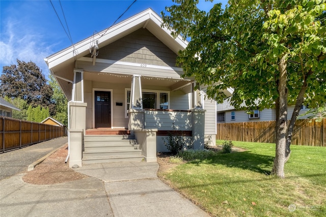 bungalow-style home featuring a porch and a front lawn