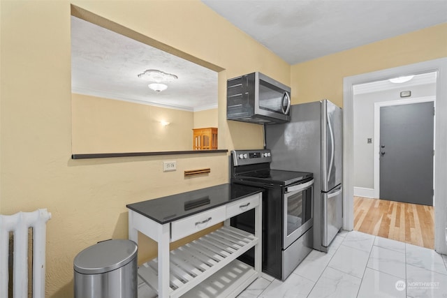 kitchen featuring crown molding, appliances with stainless steel finishes, and radiator heating unit