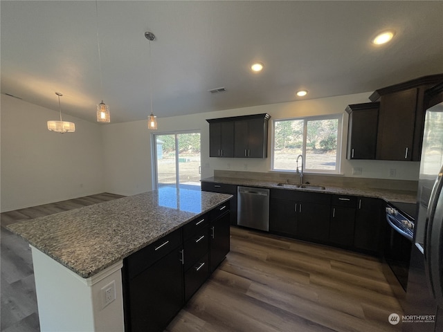 kitchen featuring a kitchen island, a sink, visible vents, appliances with stainless steel finishes, and light stone countertops