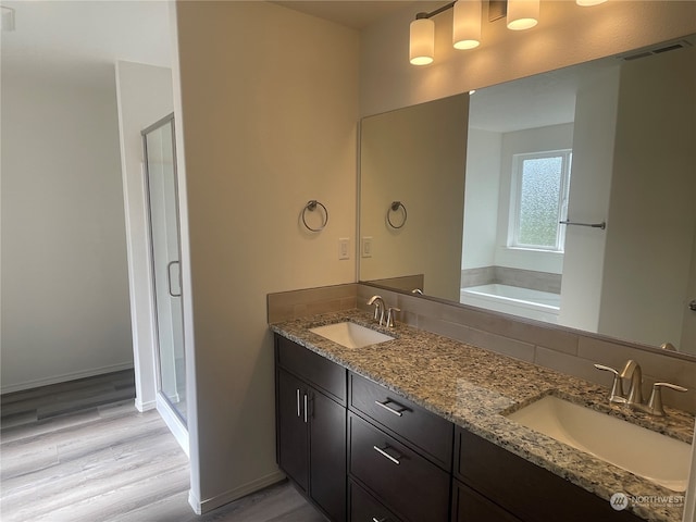 bathroom featuring shower with separate bathtub, vanity, and hardwood / wood-style floors