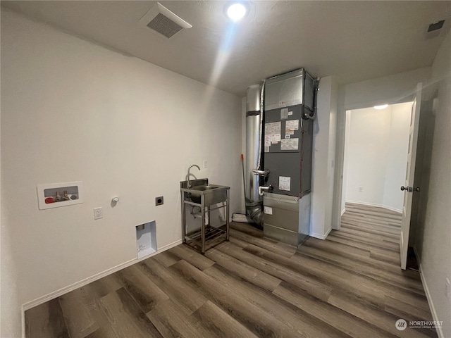 laundry room with hookup for an electric dryer, dark hardwood / wood-style floors, sink, hookup for a gas dryer, and hookup for a washing machine