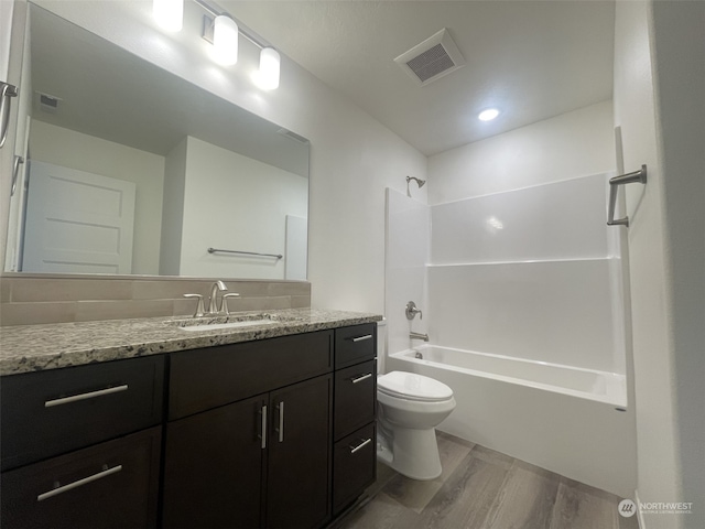 full bathroom featuring shower / bathing tub combination, vanity, hardwood / wood-style floors, and toilet