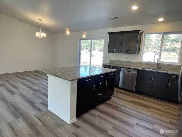 kitchen featuring hanging light fixtures, light hardwood / wood-style floors, a kitchen island, dishwasher, and sink