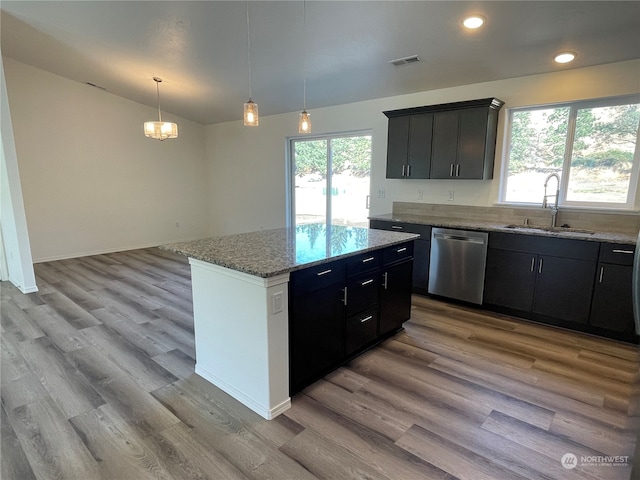 kitchen featuring dishwasher, vaulted ceiling, plenty of natural light, and a sink