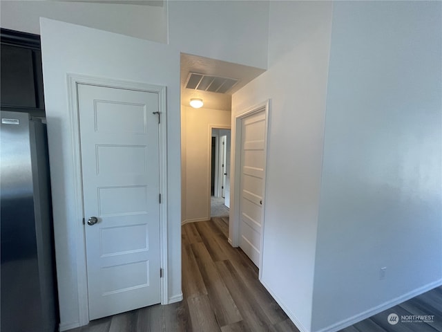 hall featuring visible vents, dark wood finished floors, and baseboards