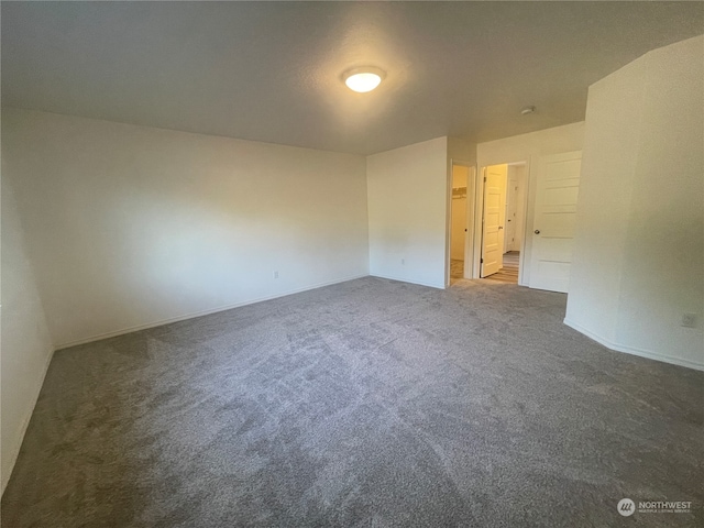 unfurnished room with dark carpet