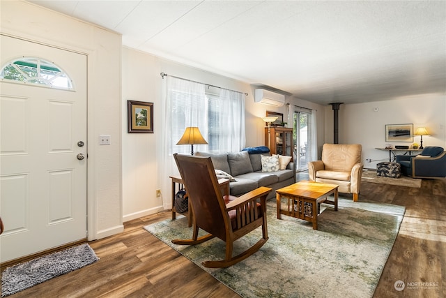 living room featuring wood-type flooring, a wall mounted AC, a wood stove, and a wealth of natural light