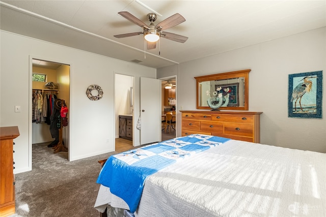 bedroom with carpet floors, a closet, ceiling fan, a walk in closet, and ensuite bath