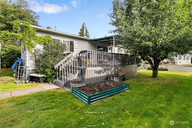 back of house with a wooden deck and a lawn