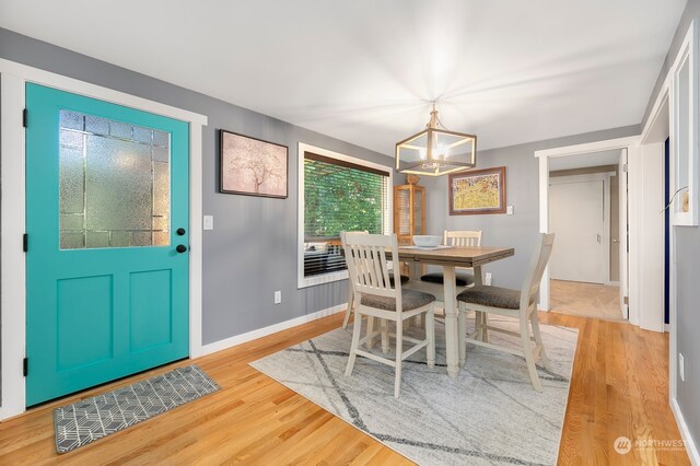 dining space featuring light hardwood / wood-style flooring and a chandelier