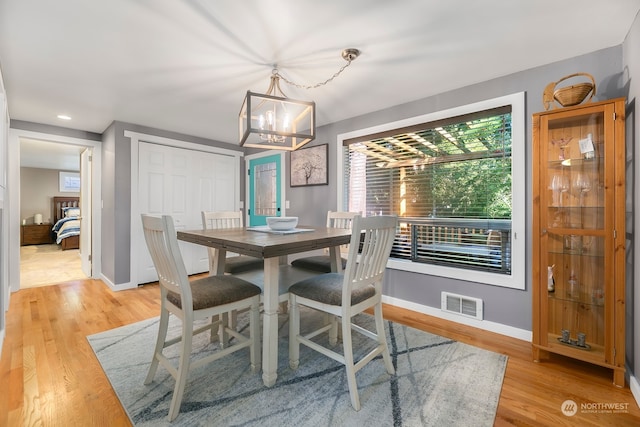 dining room with a notable chandelier and light wood-type flooring