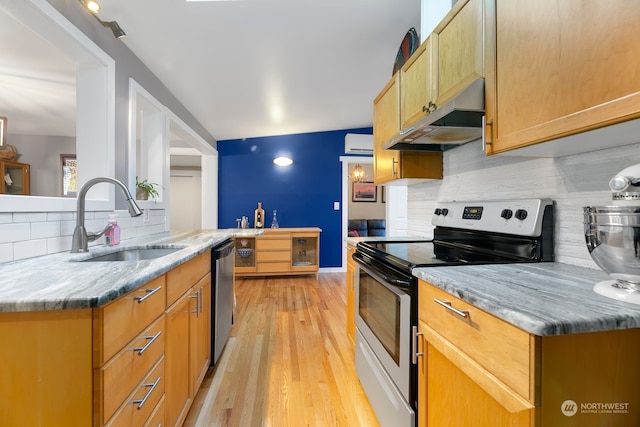 kitchen featuring appliances with stainless steel finishes, decorative backsplash, light hardwood / wood-style floors, and sink