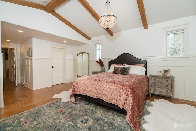 1145 School Ave, Walla Walla, WA 99362 - bedroom featuring a decorative wall, a wainscoted wall, wood finished floors, multiple windows, and a chandelier