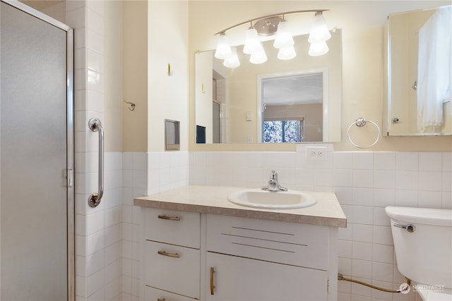 bathroom featuring tile walls, a shower with door, vanity, and toilet