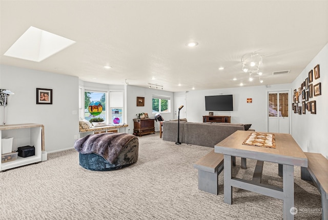 interior space with a skylight and light colored carpet