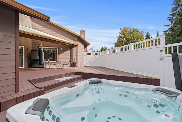 view of swimming pool featuring a deck and a hot tub