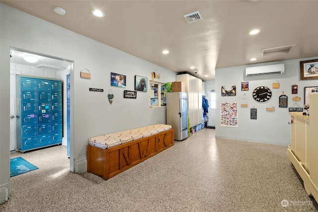 interior space featuring white refrigerator and a wall mounted air conditioner