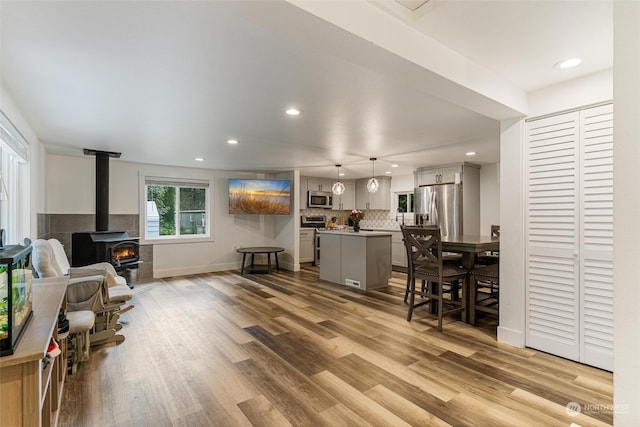 living room featuring a wood stove and light hardwood / wood-style floors