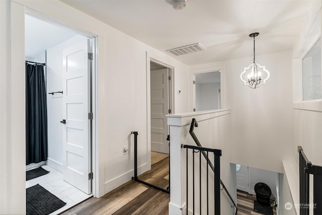 hall featuring hardwood / wood-style floors and a chandelier