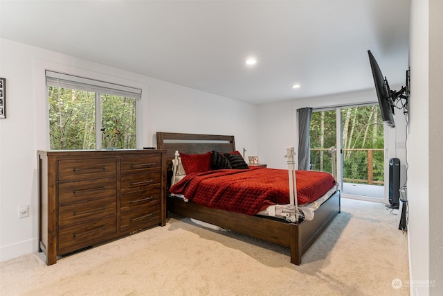 bedroom featuring light carpet, multiple windows, and access to outside