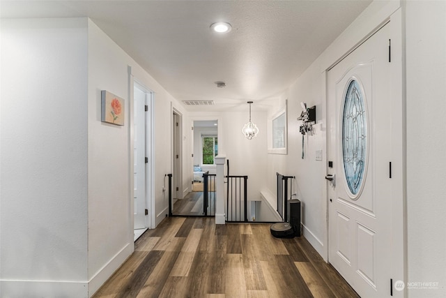 entrance foyer with dark hardwood / wood-style floors and a chandelier