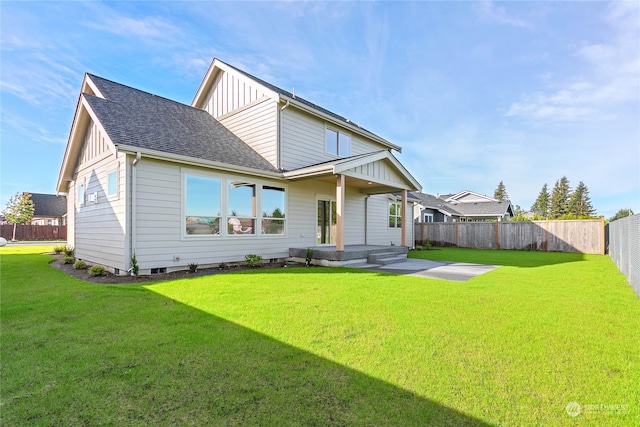 rear view of property featuring a patio area and a yard