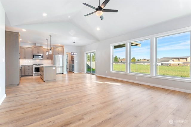 kitchen featuring light wood-type flooring, appliances with stainless steel finishes, hanging light fixtures, and a kitchen island