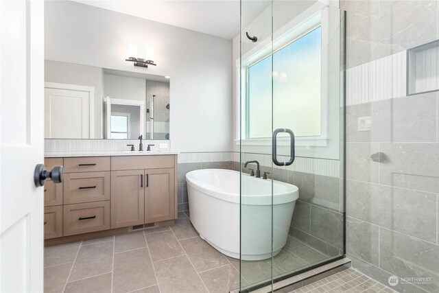 bathroom with vanity, tile walls, shower with separate bathtub, and tile patterned flooring