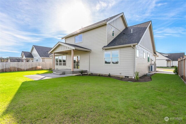 back of property with a yard and a patio area