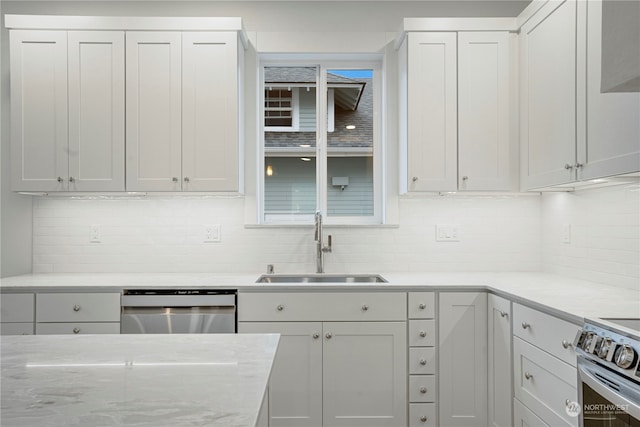 kitchen featuring white cabinets, appliances with stainless steel finishes, backsplash, and sink