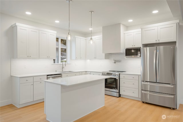 kitchen with sink, white cabinetry, stainless steel appliances, and light hardwood / wood-style flooring