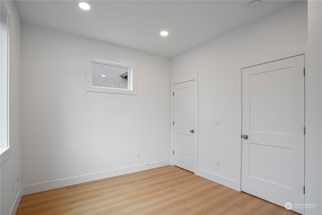 unfurnished bedroom with multiple windows and light wood-type flooring