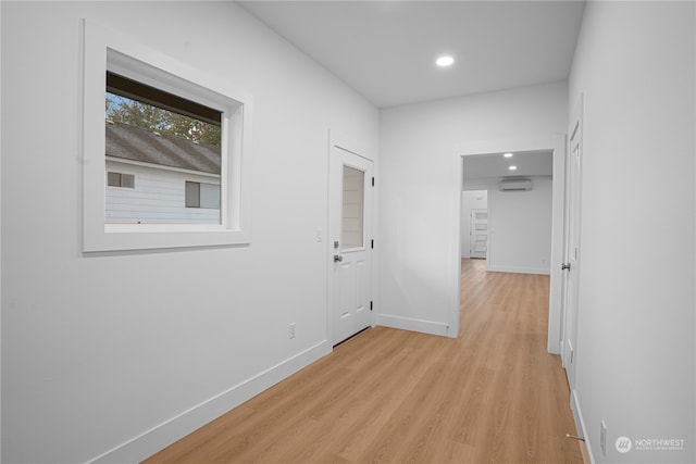 hall featuring a wall mounted AC and light wood-type flooring