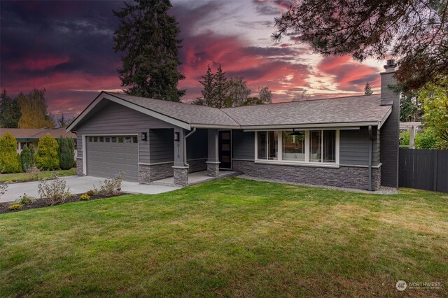 ranch-style home with a garage and a yard