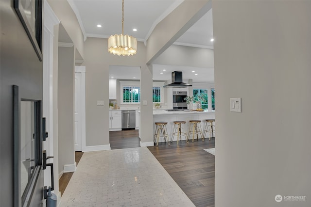 foyer entrance with ornamental molding, a notable chandelier, and dark hardwood / wood-style flooring