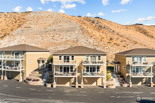 view of front of house featuring a mountain view and a balcony