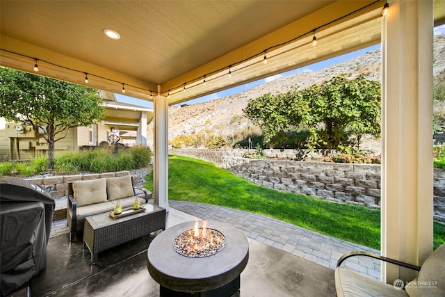 view of patio / terrace with an outdoor living space with a fire pit, a mountain view, and grilling area