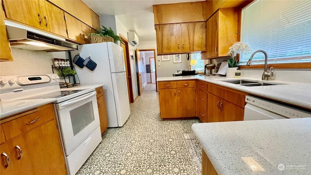 kitchen with white appliances, an AC wall unit, and sink