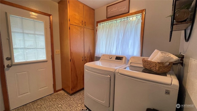 clothes washing area featuring cabinets and independent washer and dryer