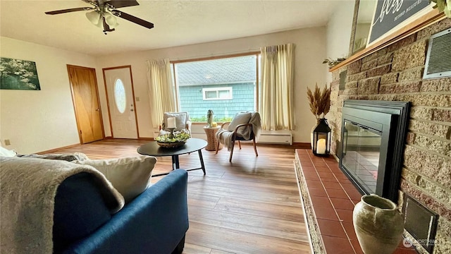 sitting room with baseboard heating, ceiling fan, and hardwood / wood-style flooring